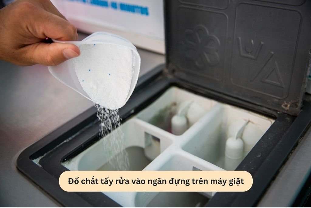 Đổ chất tẩy rửa vào ngăn đựng trên máy giặt